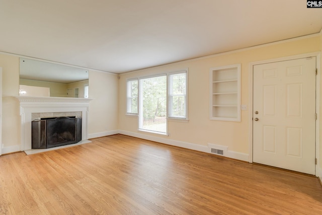 6319 Briarwood Rd, Columbia, SC 29206 - unfurnished living room with light wood-style floors, baseboards, a fireplace with flush hearth, and built in shelves