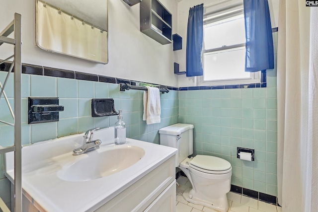 564 Rainbow Cir, West Columbia, SC 29170 - bathroom featuring tile walls, toilet, tile patterned floors, vanity, and a wainscoted wall