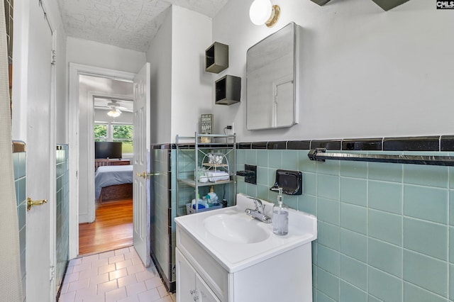564 Rainbow Cir, West Columbia, SC 29170 - bathroom featuring vanity, connected bathroom, a wainscoted wall, tile walls, and ceiling fan