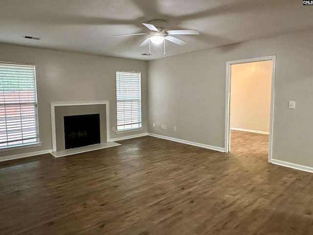 26 Someton Ct, Irmo, SC 29063 - unfurnished living room with ceiling fan, baseboards, dark wood-style flooring, and a fireplace with raised hearth