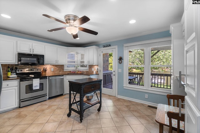 1130 Coatesdale Rd, Columbia, SC 29209 - kitchen with appliances with stainless steel finishes, dark countertops, tasteful backsplash, white cabinets, and ceiling fan
