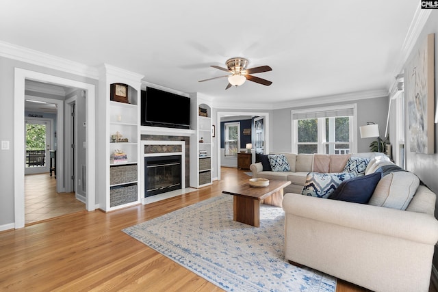 1130 Coatesdale Rd, Columbia, SC 29209 - living room featuring ornamental molding, a fireplace with flush hearth, plenty of natural light, a ceiling fan, and light wood-type flooring