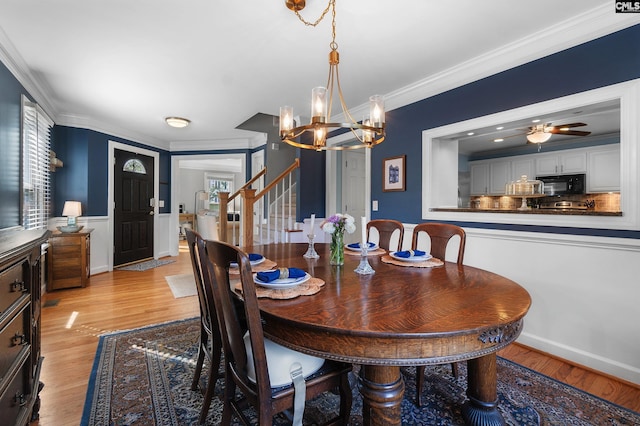 1130 Coatesdale Rd, Columbia, SC 29209 - dining area with crown molding, a chandelier, light wood-type flooring, stairs, and wainscoting
