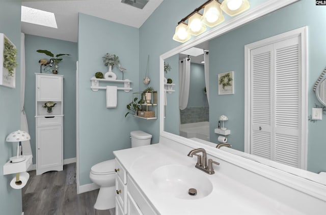 213 Windwood Dr, Elgin, SC 29045 - bathroom featuring a closet, toilet, a skylight, vanity, and wood finished floors