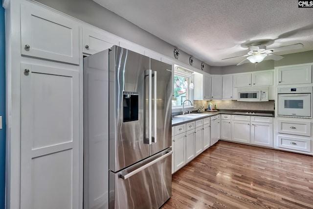 225 King Charles Rd, Columbia, SC 29209 - kitchen featuring white appliances, a sink, a textured ceiling, white cabinets, and wood finished floors