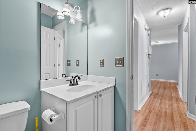 140 Whispering Glen Cir, West Columbia, SC 29170 - bathroom featuring toilet, vanity, wood finished floors, a textured ceiling, and baseboards