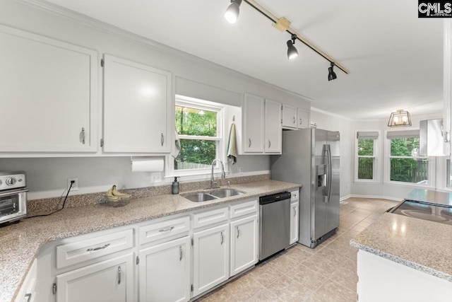 6304 Christie Rd, Columbia, SC 29209 - kitchen featuring appliances with stainless steel finishes, a sink, white cabinets, plenty of natural light, and ornamental molding