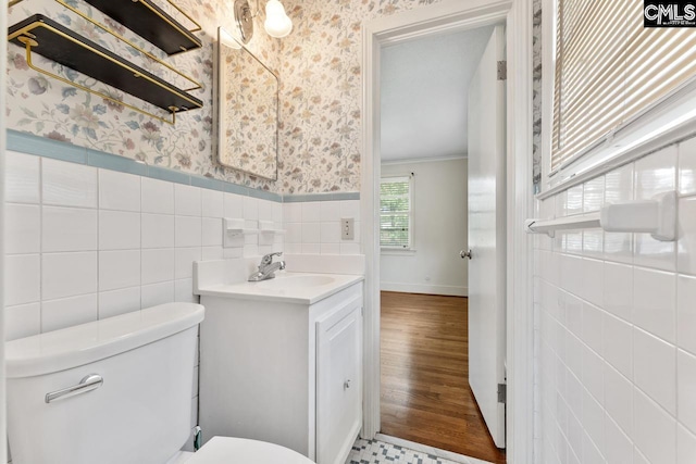 200 Shady Ln, Cayce, SC 29033 - half bathroom with wallpapered walls, tile walls, toilet, vanity, and a wainscoted wall