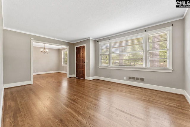 200 Shady Ln, Cayce, SC 29033 - unfurnished living room featuring a chandelier, ornamental molding, baseboards, wood finished floors, and a textured ceiling