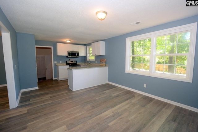 4257 Donavan Dr, Columbia, SC 29210 - kitchen with stainless steel appliances, white cabinetry, baseboards, and a peninsula