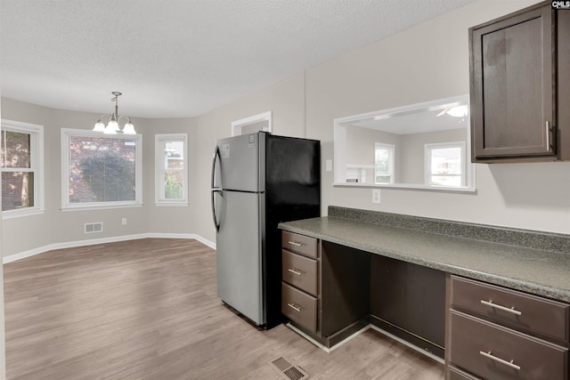 220 Colchester Dr, Columbia, SC 29223 - kitchen with freestanding refrigerator, dark brown cabinets, light wood-type flooring, a chandelier, and a textured ceiling