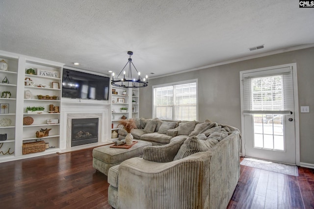 113 Dutch Oaks Dr, Irmo, SC 29063 - living room with a chandelier, a textured ceiling, dark wood-type flooring, crown molding, and a glass covered fireplace