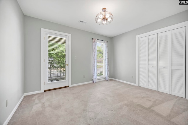 101 Stephenson Ln, Columbia, SC 29212 - unfurnished bedroom featuring a chandelier, carpet, access to exterior, baseboards, and a closet