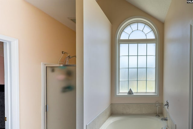6126 Slab Landing Dr, Cope, SC 29038 - bathroom featuring vaulted ceiling, healthy amount of natural light, a bath, and a shower stall