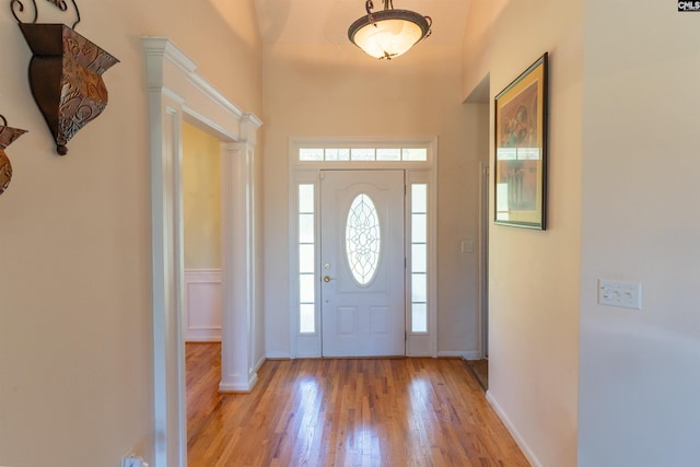 6126 Slab Landing Dr, Cope, SC 29038 - foyer entrance featuring light wood-style floors, baseboards, a towering ceiling, and decorative columns