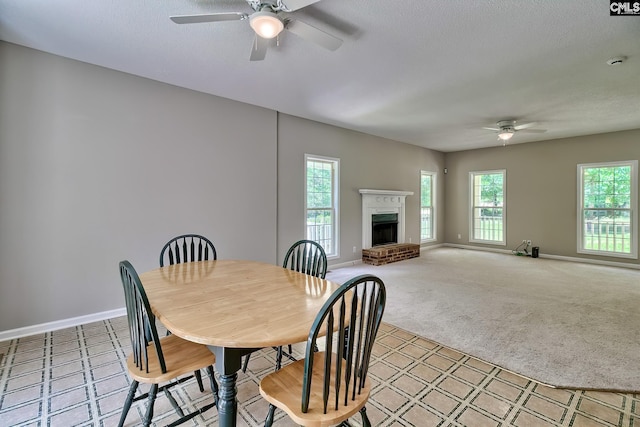 198 Beaver Creek Cir, Lugoff, SC 29078 - dining area featuring a ceiling fan, baseboards, a brick fireplace, light carpet, and a textured ceiling