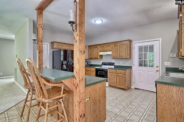 198 Beaver Creek Cir, Lugoff, SC 29078 - kitchen with electric range oven, black refrigerator with ice dispenser, under cabinet range hood, a sink, and a breakfast bar