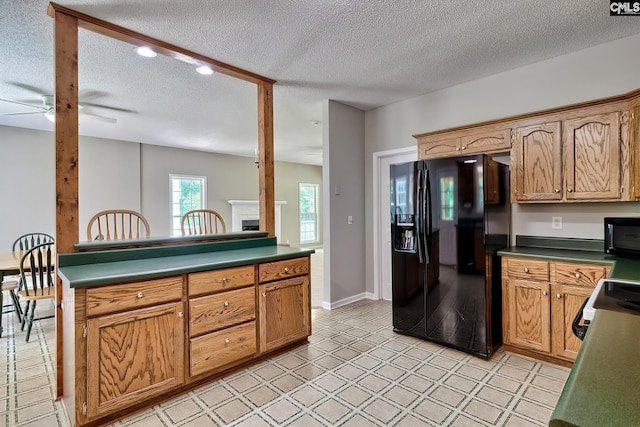 198 Beaver Creek Cir, Lugoff, SC 29078 - kitchen with black appliances, ceiling fan, a textured ceiling, dark countertops, and a fireplace