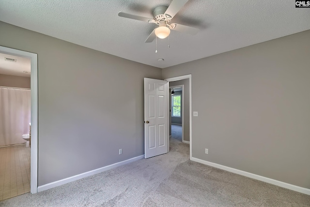 198 Beaver Creek Cir, Lugoff, SC 29078 - unfurnished bedroom featuring baseboards, carpet floors, connected bathroom, ceiling fan, and a textured ceiling