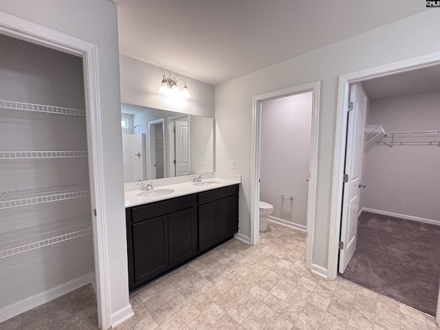 184 Windfall Rd, Blythewood, SC 29016 - full bathroom with double vanity, a spacious closet, toilet, and baseboards
