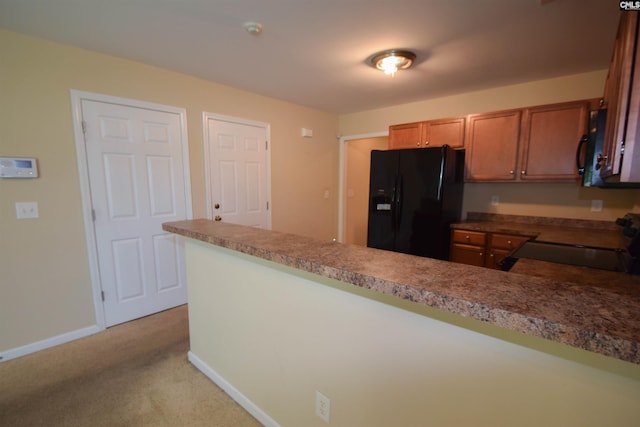 267 Courtside Dr, Lexington, SC 29073 - kitchen with black appliances, brown cabinets, a peninsula, light carpet, and baseboards