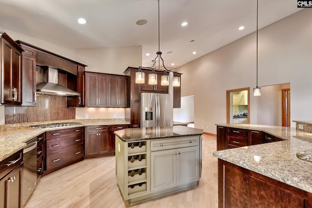 940 Willow Cove Rd, Chapin, SC 29036 - kitchen with wall chimney exhaust hood, stainless steel appliances, light wood-style floors, a kitchen island, and light stone countertops