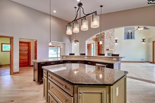 940 Willow Cove Rd, Chapin, SC 29036 - kitchen with a kitchen island, ceiling fan, open floor plan, light wood-style flooring, and arched walkways