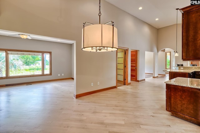 940 Willow Cove Rd, Chapin, SC 29036 - kitchen featuring high vaulted ceiling, arched walkways, light wood finished floors, light stone counters, and ceiling fan