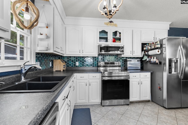 336 S Royal Tower Dr, Irmo, SC 29063 - kitchen with stainless steel appliances, a sink, dark countertops, white cabinets, and crown molding