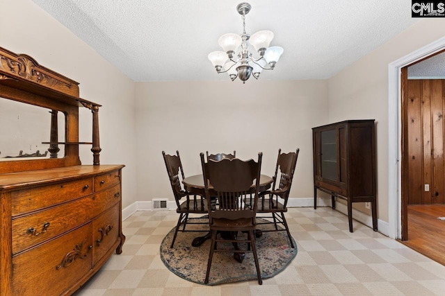 26 Carroll Ct, West Columbia, SC 29170 - dining room with light floors, a chandelier, a textured ceiling, and baseboards