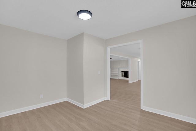 248 Shareditch Rd, Columbia, SC 29210 - unfurnished room with light wood-type flooring, baseboards, and a brick fireplace