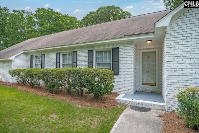 248 Shareditch Rd, Columbia, SC 29210 - view of exterior entry with brick siding, roof with shingles, and a lawn