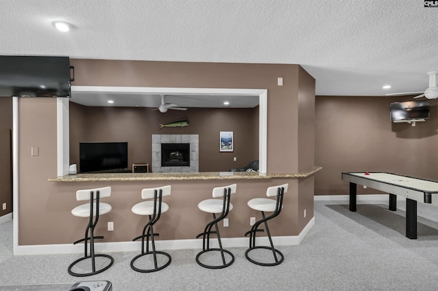 520 Sail Point Way, Columbia, SC 29212 - kitchen featuring a ceiling fan, a textured ceiling, carpet flooring, baseboards, and a tiled fireplace