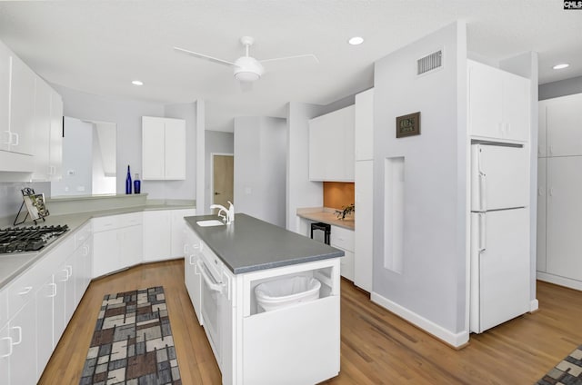 520 Sail Point Way, Columbia, SC 29212 - kitchen featuring freestanding refrigerator, stainless steel gas stovetop, wood finished floors, an island with sink, and white cabinetry