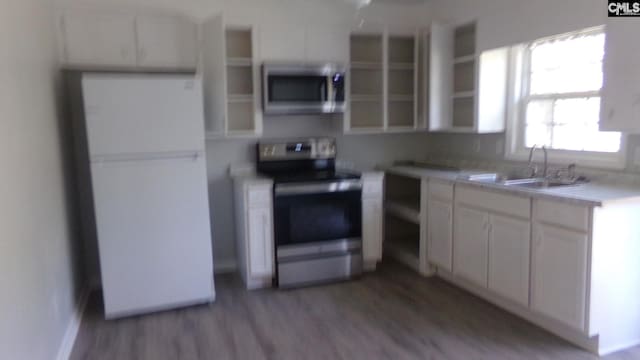 3208 Downes Grove Rd, Columbia, SC 29209 - kitchen with stainless steel appliances, a sink, light wood finished floors, white cabinets, and light countertops
