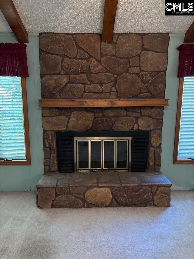 100 Clee Hill Ct, Irmo, SC 29063 - detailed view of a stone fireplace, carpet, beam ceiling, and a textured ceiling