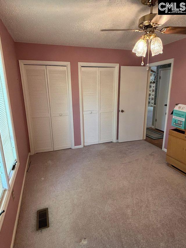 100 Clee Hill Ct, Irmo, SC 29063 - unfurnished bedroom featuring two closets, carpet, a ceiling fan, a textured ceiling, and baseboards