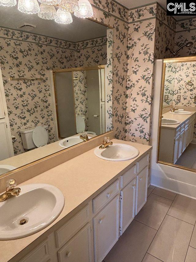 100 Clee Hill Ct, Irmo, SC 29063 - full bath featuring a stall shower, tile patterned floors, wallpapered walls, toilet, and double vanity