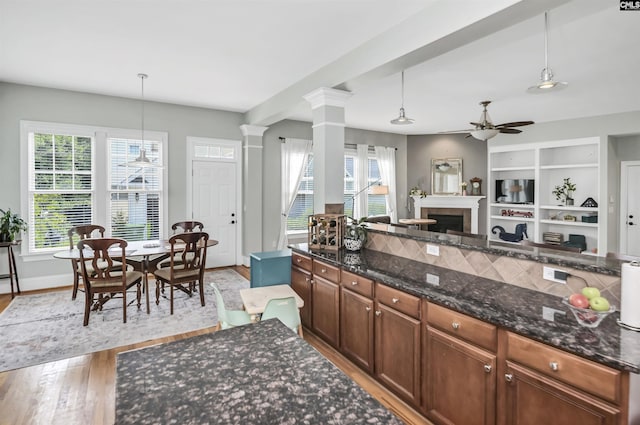 128 Van Der Horst Dr, Columbia, SC 29229 - kitchen featuring a ceiling fan, light wood-style flooring, ornate columns, a fireplace, and pendant lighting