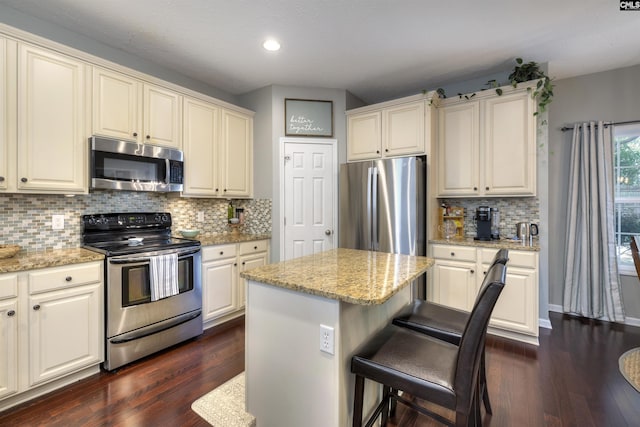 301 Spring Mist Ct, Lexington, SC 29072 - kitchen featuring stainless steel appliances, dark wood-type flooring, recessed lighting, a breakfast bar area, and light stone countertops