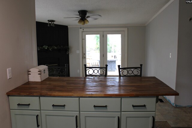 35 Wood Lake Dr, Lugoff, SC 29078 - kitchen with wood counters, ceiling fan, ornamental molding, white cabinets, and a textured ceiling