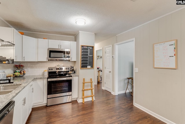 317 Westbridge Rd, Columbia, SC 29223 - kitchen with appliances with stainless steel finishes, tasteful backsplash, dark wood finished floors, white cabinetry, and crown molding