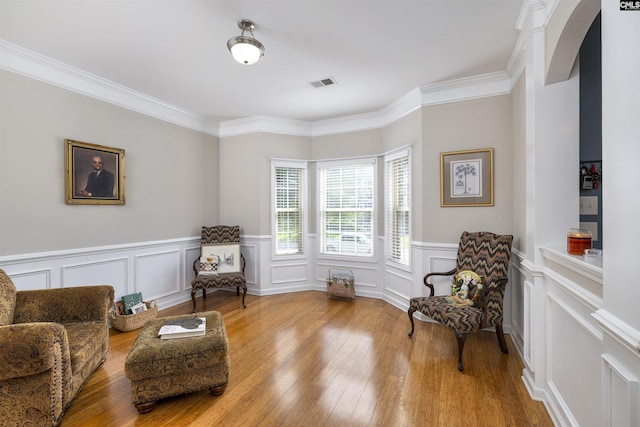 22 Genesis Ln, Camden, SC 29020 - living area with hardwood / wood-style floors, a decorative wall, crown molding, wainscoting, and arched walkways