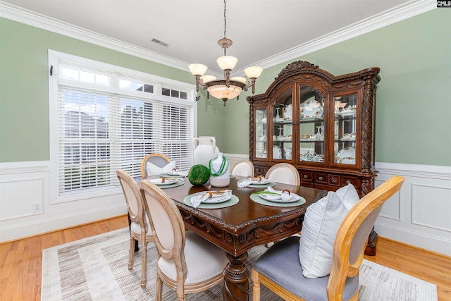 107 Sherborne Ln, Columbia, SC 29229 - dining space featuring a wainscoted wall, a chandelier, ornamental molding, light wood-style flooring, and a decorative wall