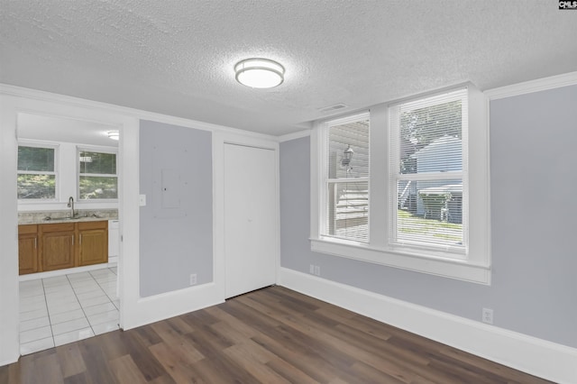 2217 Blossom St, Columbia, SC 29205 - unfurnished dining area featuring a sink, a textured ceiling, dark wood-style flooring, ornamental molding, and baseboards