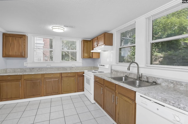 2217 Blossom St, Columbia, SC 29205 - kitchen featuring white appliances, a sink, under cabinet range hood, brown cabinets, and light tile patterned floors