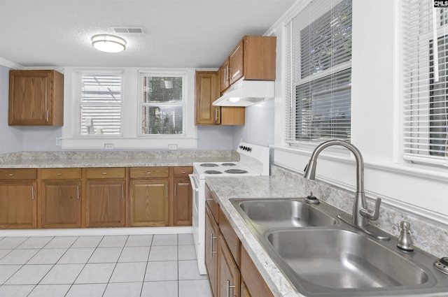 2217 Blossom St, Columbia, SC 29205 - kitchen featuring white electric stove, under cabinet range hood, a sink, brown cabinets, and a textured ceiling