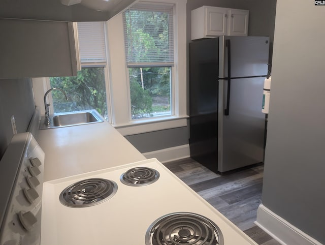 2217 Blossom St, Columbia, SC 29205 - kitchen with freestanding refrigerator, a sink, dark wood-type flooring, light countertops, and baseboards