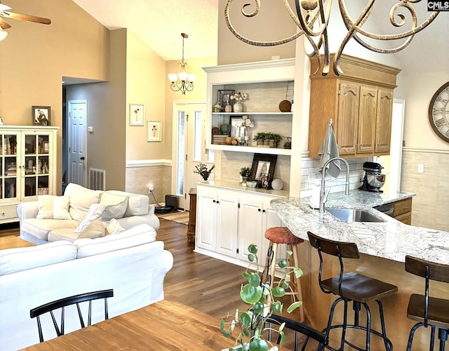 10 Tambridge Ct, Columbia, SC 29229 - kitchen featuring a sink, a chandelier, light stone counters, a kitchen breakfast bar, and dark wood-type flooring