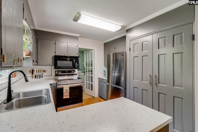 1302 Sunnyhill Dr, Camden, SC 29020 - kitchen with stainless steel appliances, a sink, crown molding, gray cabinetry, and light wood finished floors